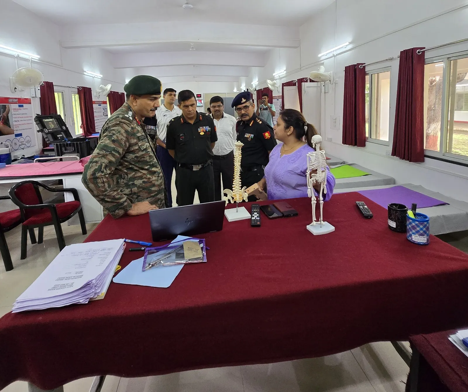 Senior Army officers being briefed across a table laid with spine and skeleton models